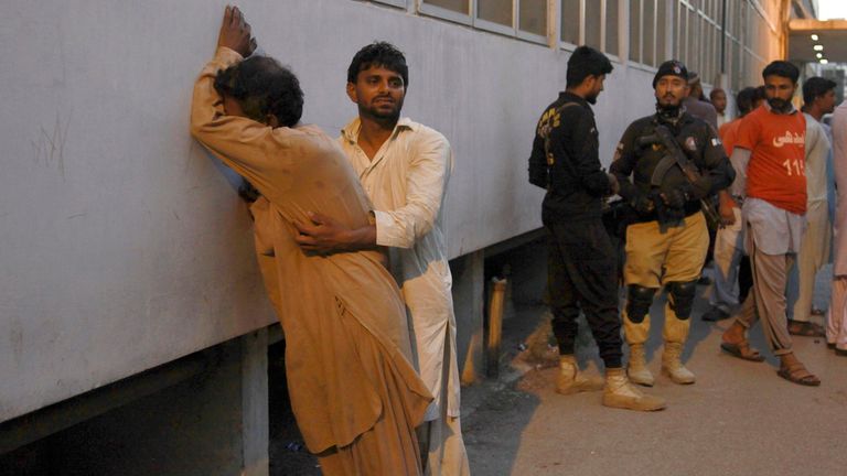 A man comforts to another mourns on the dead of his family member in the stampede, at outside a morgue, in Karachi, Pakistan, Friday, March 31, 2023.  Several people were killed in the deadly stampede at a Ramadan food distribution center outside a factory in Pakistan&#39;s southern port city of Karachi, police and rescue officials said.    (AP Photo/Ikram Suri)