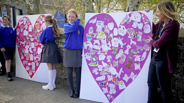 Pupils and teachers from Aldington Primary School pay their respects to Paul O'Grady with picture collages of their drawing of dogs along the route of his funeral in the village of Aldington, Kent ahead of his funeral at St Rumwold's Church. Picture date: Thursday April 20, 2023.