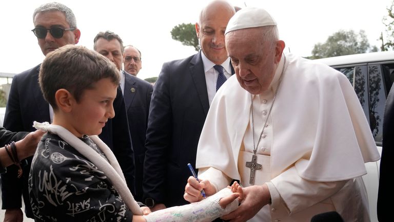 Pope Francis autographs the plaster cast of a child as he leaves the Agostino Gemelli University Hospital in Rome, Saturday, April 1, 2023 after receiving treatment for a bronchitis, The Vatican said. Francis was hospitalized on Wednesday after his public general audience in St. Peter&#39;s Square at The Vatican. (AP Photo/Gregorio Borgia)