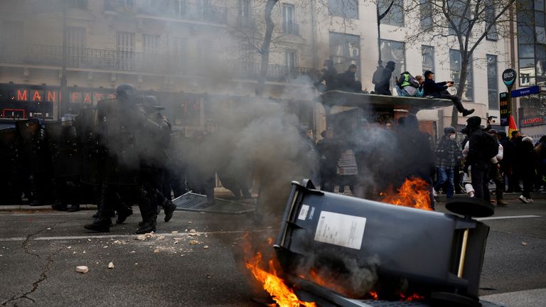 Protesters stand on a bus stop near burning garbage bins during clashes at a demonstration as part of the eleventh day of nationwide strikes and protests against French government&#39;s pension reform, in Paris, France, April 6, 2023. REUTERS/Sarah Meyssonnier