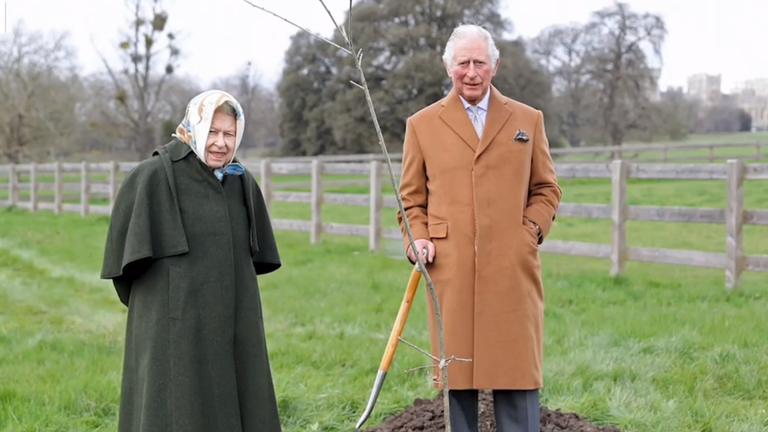 Queen Elizabeth plants a tree with Prince Charles.