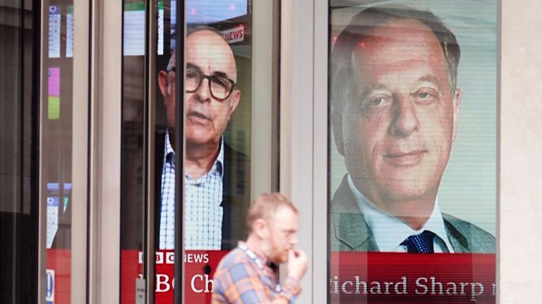 A screen showing a news report through the windows of the BBC in central London, of BBC chairman Richard Sharp 