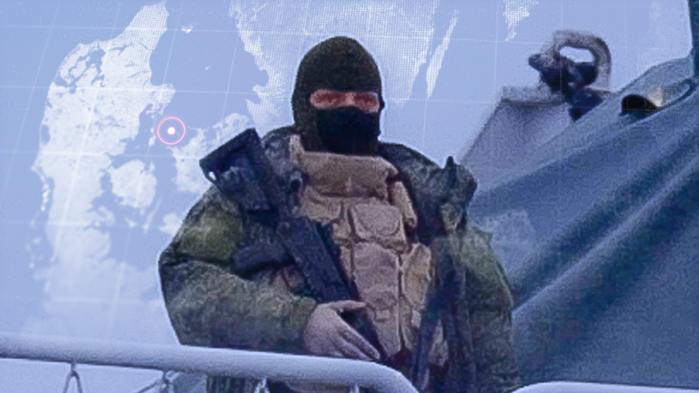 A man wearing a balaclava and military gear, who is carrying an assault rifle, appears on the deck of the Admiral Vladimirsky. Pic: Morten Kruger/DR