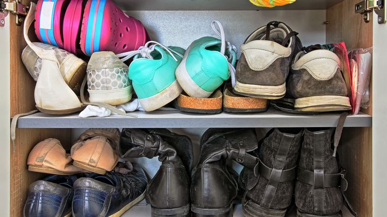 Variety of different  shoes packed in a wardrobe

