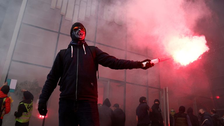 French SNCF railway workers on strike, holding red flares, gather in front of the headquarters of stock market operator Euronext at La Defense business and financial district as part of a "day of expression of railway anger" following months of strikes and a failed attempt to halt pension reforms, in Courbevoie near Paris, France, April 20, 2023. REUTERS/Benoit Tessier
