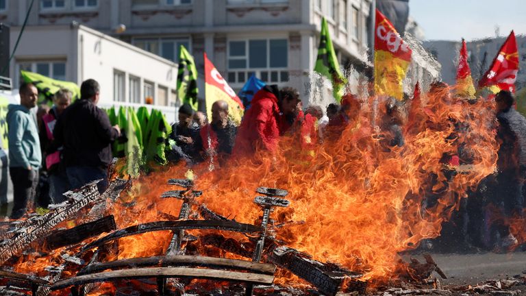 French SNCF railway workers on strike, holding French CGT and Sud Rail labour unions, gather near burning wooden pallets at Gare de Lyon train station as part of a 