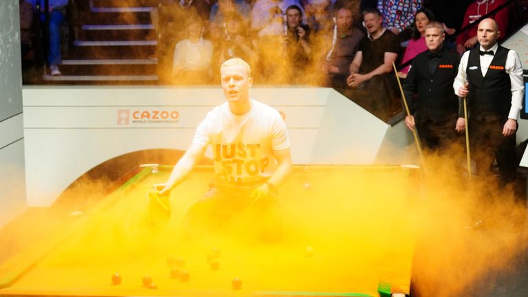 A Just Stop Oil protestor jumps on the table at the World Snooker Championships