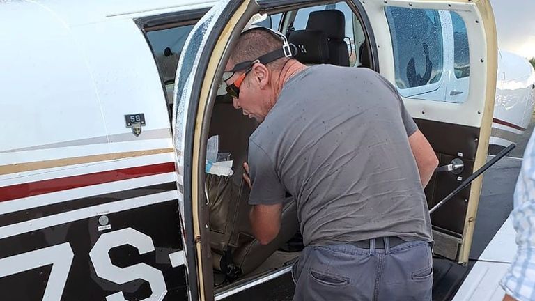 Brian Emmenis, fire officer and snake handler Johan de Klerk looks inside a plane, in Welkom, South Africa, as he searches for a venomous snake 