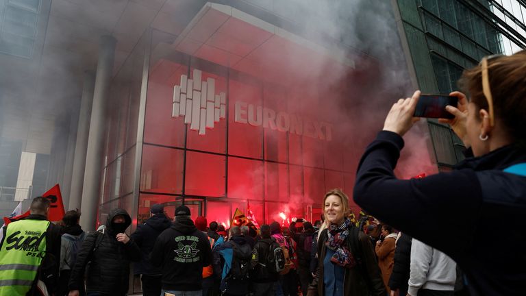 French SNCF railway workers on strike, holding flags of French CGT and Sud Rail labour unions, enter the headquarters of stock market operator Euronext at La Defense business and financial district as part of a 