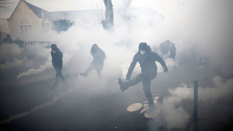 Masked protesters react amid tear gas during clashes at a demonstration as part of the eleventh day of nationwide strikes and protests against French government&#39;s pension reform, in Rennes, France, April 6, 2023. REUTERS/Stephane Mahe
