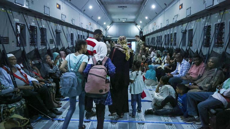 Families gather aboard an RAF plane during the evacuation from Wadi Seidna Air Base