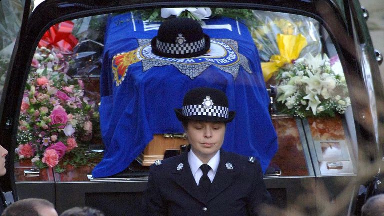 WPC Teresa Milburn after placing the hat of her colleague WPC Sharon Beshenivsky on top of her coffin as they leave Bradford Cathedral, following her funeral service.
