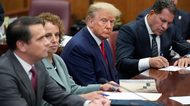 Former President Donald Trump sits at the defense table with his defense team in a Manhattan court