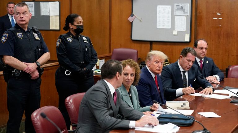 Former President Donald Trump sits at the defence table