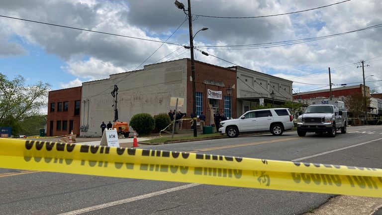 Investigators work at the site of a fatal shooting in downtown Dadeville