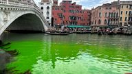 Gondolas navigate by the Rialto Bridge on Venice&#39;s historical Grand Canal as a patch of phosphorescent green liquid spreads in it, Sunday, May 28, 2023. The governor of the Veneto region, Luca Zaia, said that officials had requested the police to investigate to determine who was responsible, as environmental authorities were also testing the water. (AP Photo/Luigi Costantini)