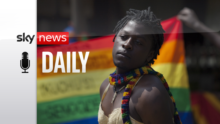 A transgender Ugandan poses in front of a rainbow flag during the 3rd Annual Lesbian, Gay, Bisexual and Transgender (LGBT) Pride celebrations in Entebbe, Uganda, Saturday, Aug. 9, 2014. Scores of Ugandan homosexuals and their supporters are holding a gay pride parade on a beach in the lakeside town of Entebbe. The parade is their first public event since a Ugandan court invalidated an anti-gay law that was widely condemned by some Western governments and rights watchdogs. (AP Photo/Rebecca Vassi