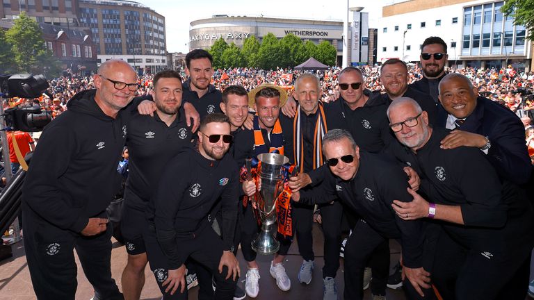 Luton Town manager Rob Edwards (centre) holds up the trophy with the coaching staff 
