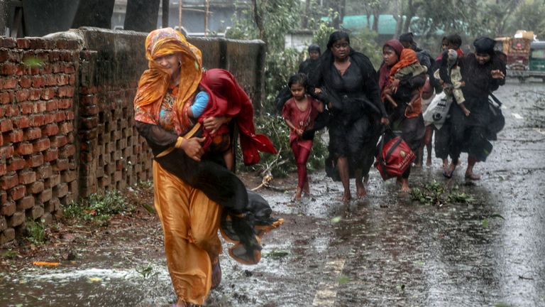 People move from their homes to take shelter in the nearest cyclone shelter at Shah Porir Dwip during the landfall of cyclone Mocha in Teknaf, Bangladesh