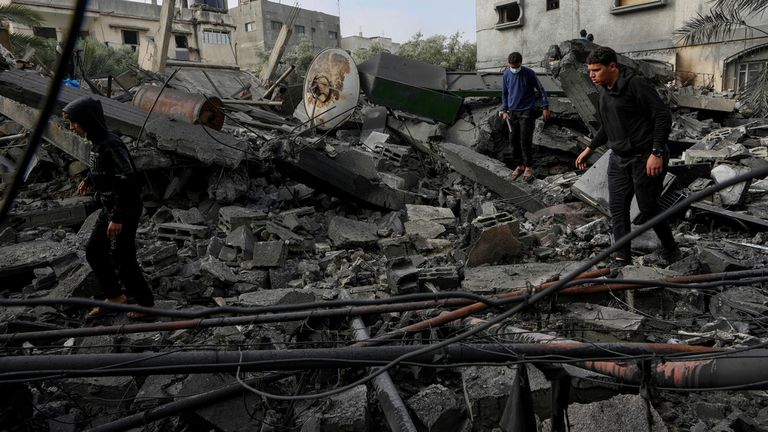 Filistinliler, bir saldırıda vurulan bir evin enkazını inceliyor.  Resim: AP