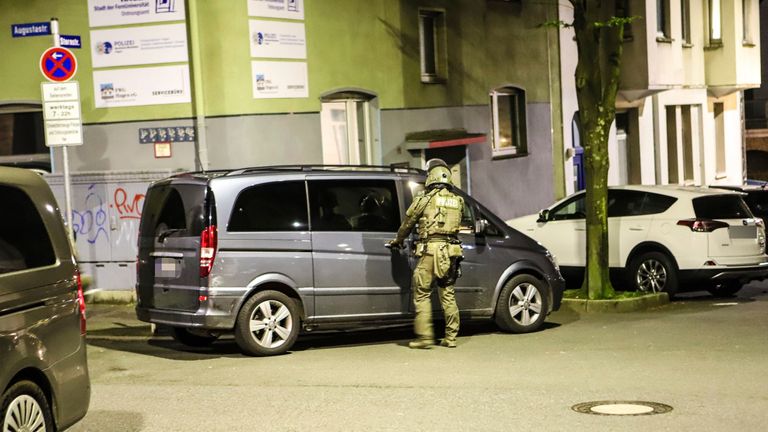 A police officer stands by a van during a raid in Hagen
Pic:AP