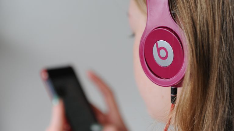 A teenager uses a pair of Solo HD Beats headphones by Dr Dre and an Apple iPhone, as Apple will make the most expensive acquisition in its history, after confirming a deal to buy Dr Dre&#39;s Beats Electronics for 3 billion dollars (£1.78 billion).