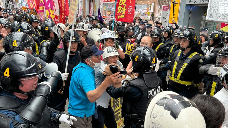 Protesters confront riot police during a march against the Group of Seven (G7) meeting being held in Hiroshima, western Japan, Sunday, May 21, 2023. (AP Photo/Adam Schreck)