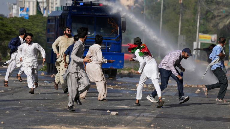 Police use a water cannon to disperse supporters of Pakistan&#39;s former Prime Minister Imran Khan protesting against the arrest of their leader, in Karachi, Pakistan
Pic:AP