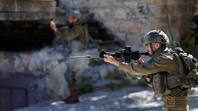 An Israeli soldier shoots rubber bullets at Palestinians during clashes following the death of Palestinian prisoner Khader Adnan during a hunger strike in an Israeli jail, in Hebron in the Israeli-occupied West Bank May 2,2023. REUTERS/Mussa Issa Qawasm
