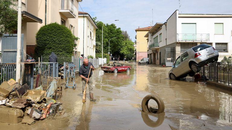 Bir sakin, 18 Mayıs 2023'te İtalya'nın Faenza kentinde, İtalya'nın Emilia Romagna bölgesini şiddetli yağışların vurmasının ardından çamur ve molozu temizliyor. REUTERS/Claudia Greco