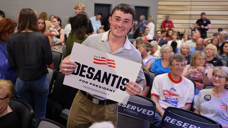 20-year-old Jack Spoonmore of Adel, Iowa holds a Ron DeSantis campaign sign