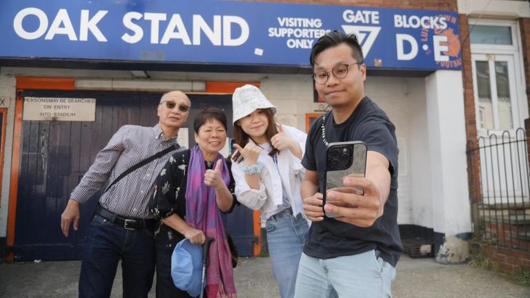 Tourists take a picture outside the stadium