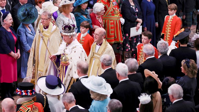 Britain&#39;s King Charles III wears the Imperial State Crown and holds the Sovereign&#39;s Orb and Sceptre as he leaves after his coronation ceremony, at Westminster Abbey, in London, Saturday, May 6, 2023. Prince George is at top right. (Phil Noble/Pool Photo via AP)