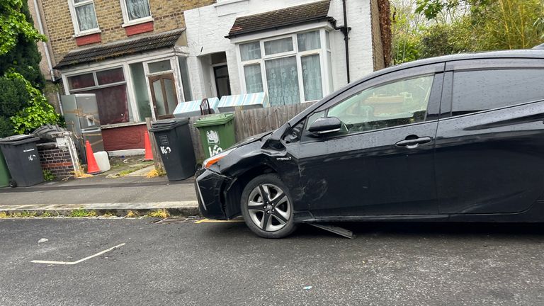 A damaged car on Malyons Road in Lewisham where a man was stabbed before reportedly driving a BMW into parked cars