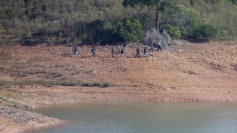A police search team work on the shore of the Arade dam. Pic: AP