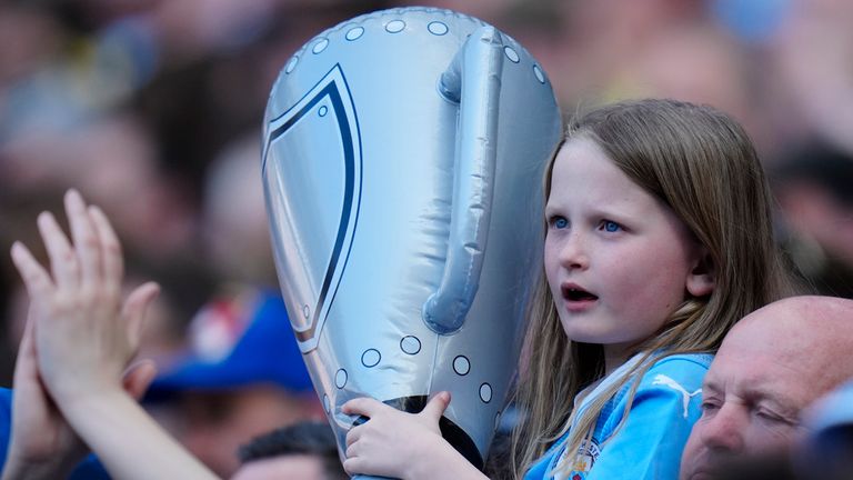 A young supporter holds mock trophy during the English Premier League