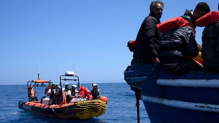 A Rip rescue speed boat by MSF approaches a broken down fishing vessel with over 600 migrants on board.