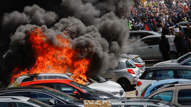 Black smoke billows from a burning car as demonstrators take part in the traditional May Day labour march, a day of mobilisation against the French pension reform law and for social justice, in Nantes, France May 1, 2023. REUTERS/Stephane Mahe
