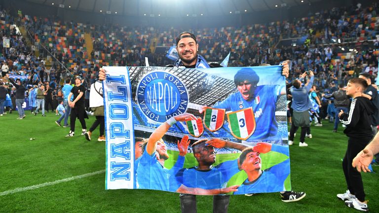 Napoli fans celebrate winning Serie A on the pitch after the match