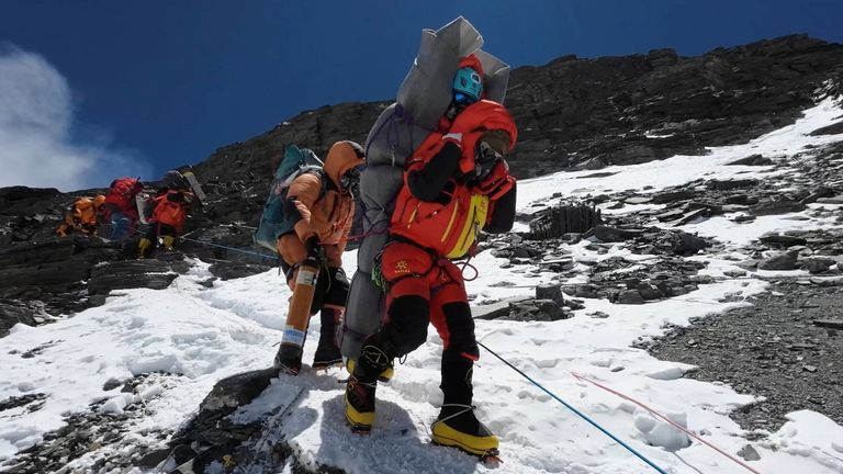 Ngima Tashi Sherpa walks as he carries a Malaysian climber while rescuing him from the death zone above camp four at Everest, Nepal, May 18, 2023 in this screengrab obtained from a handout video. Gelje Sherpa/Handout via REUTERS THIS IMAGE HAS BEEN SUPPLIED BY A THIRD PARTY. MANDATORY CREDIT
