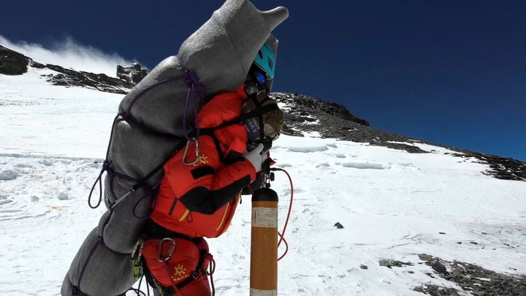 Ngima Tashi Sherpa walks as he carries a Malaysian climber while rescuing him from the death zone above camp four at Everest, Nepal, May 18, 2023 in this screengrab obtained from a handout video. Gelje Sherpa/Handout via REUTERS THIS IMAGE HAS BEEN SUPPLIED BY A THIRD PARTY. MANDATORY CREDIT
