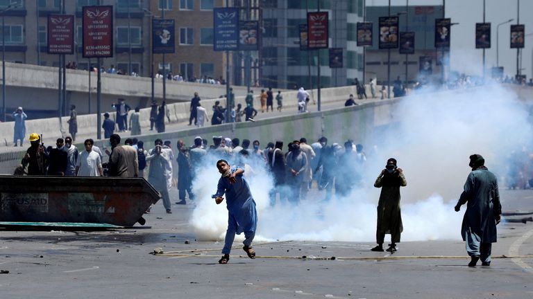 Supporters of Imran Khan throw stones towards police during a protest against his arrest, in Peshawar, Pakistan