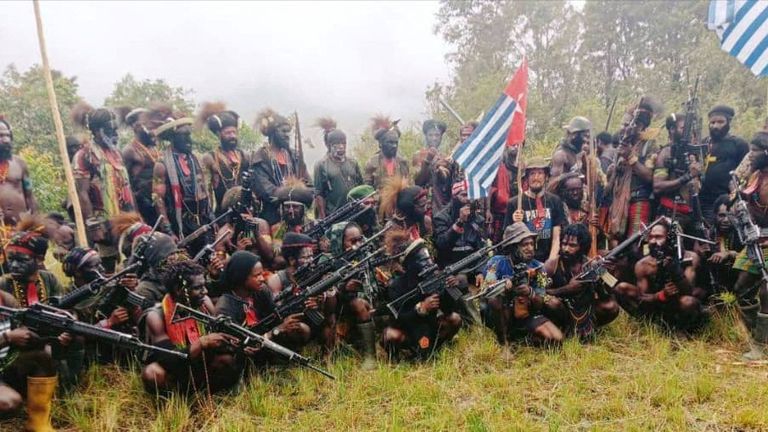 A man who is identified as Philip Mehrtens, the New Zealand pilot who is said to be held hostage by a pro-independence group, sits among separatist fighters in Indonesia&#39;s Papua region in this undated handout picture released on May 26, 2023. Pic: The West Papua National Liberation Army (TPNPB)/REUTERS