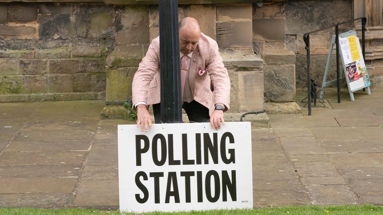 A polling station sign is adjusted outside the polling station in Bridlington Priory Church, Yorkshire. 