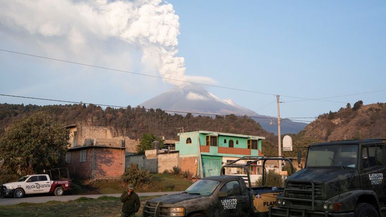 A soldier stands at a checkpoint that blocks the access to Paso de Cortes while the Popocatepetl volcano spews a column of steam and ashes, as seen from San Nicolas de los Ranchos, in Puebla state, Mexico May 23, 2023. REUTERS/Armando Vega NO RESALES. NO ARCHIVES
