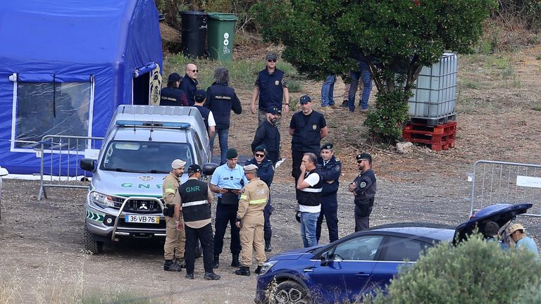 Police officers talk by an operation tent near Barragem do Arade, Portugal 
Pic:AP