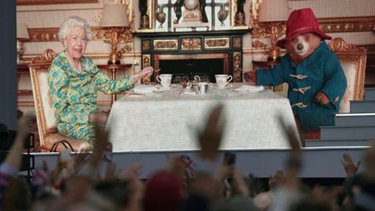 A crowd watches the Queen having tea with Paddington Bear on a big screen during the Platinum Jubilee 