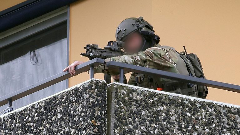 A police officer was seen aiming a gun from a balcony nearby. Pic: AP