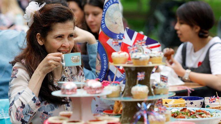 A woman looks on as people celebrate Britain&#39;s King Charles&#39; coronation with the Big Lunch at Regent&#39;s Park, in London, Britain, May 7, 2023. REUTERS/Piroschka Van De Wouw
