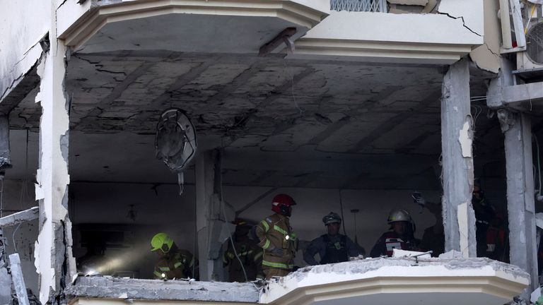 Rescue workers inspect a house in Rehovot destroyed by  rocket fired from the Gaza Strip on 11 May Pic: AP 